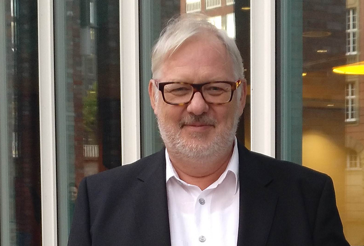 Bernd Wenske vor Glasfassade, Blick in die Kamera, Mentor für Führung und HR im Mittelstand